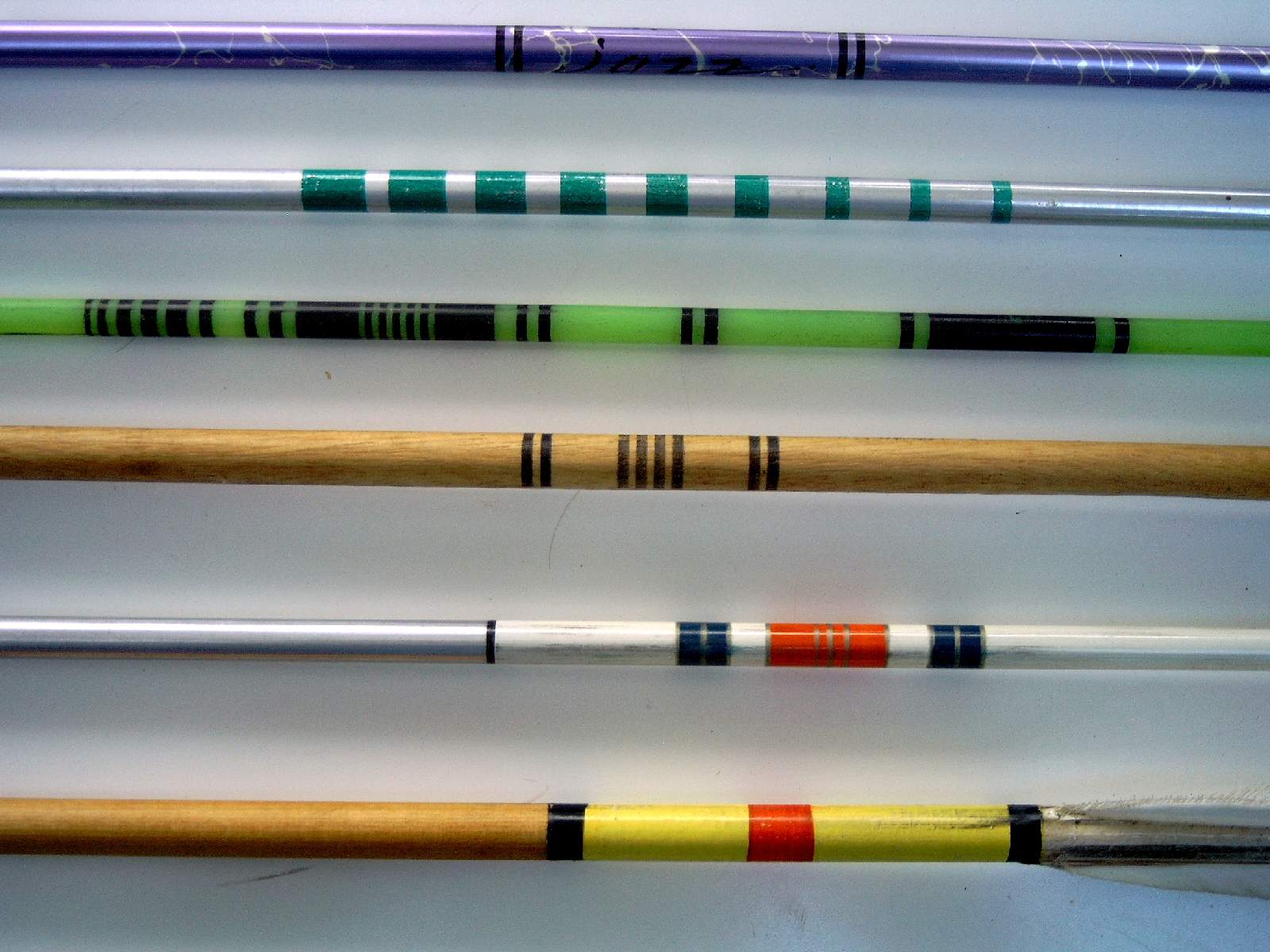Traditional arrow shafts with cresting bands — colored ring patterns near the fletching for matched-set identification